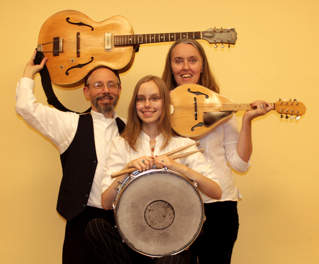 Photo of Jutta & the Hi-Dukes (tm) as a trio - From left to right: Terran Doehrer holding guitar, Zoï Doehrer holding percussion, Jutta Distler holding mandolin. Photo by Betina Distler. © 2012 Modal Music, Inc. (tm) All rights reserved.